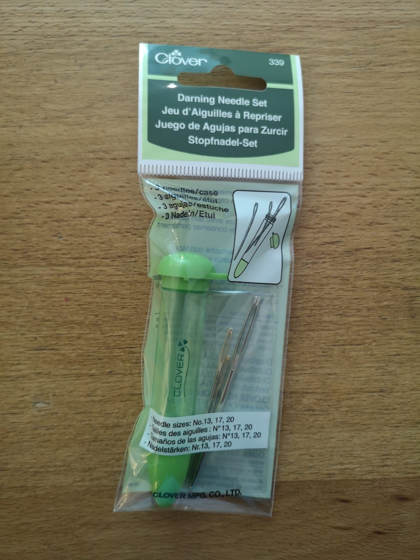 The darning needle set, featuring 3 different sizes needles. It comes with a green plastic cylindrical case. 